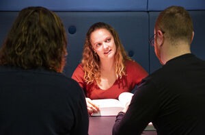 Three students who are discussing. Photo.